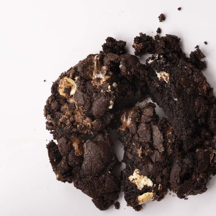 A real Triple Chocolate cookie photographed from above — tap to eat it, bite by bite